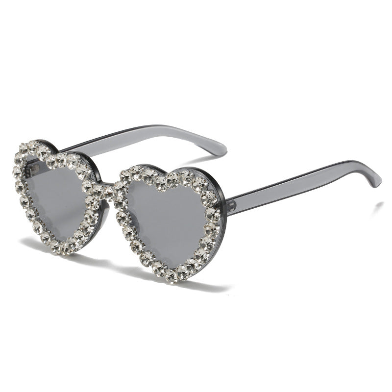 Heart-shaped sunglasses with rhinestone detailing on a white background