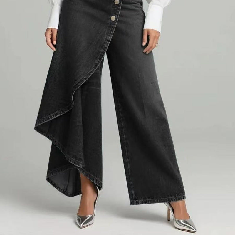 Person wearing black wide-leg jeans with a white shirt on a gray background