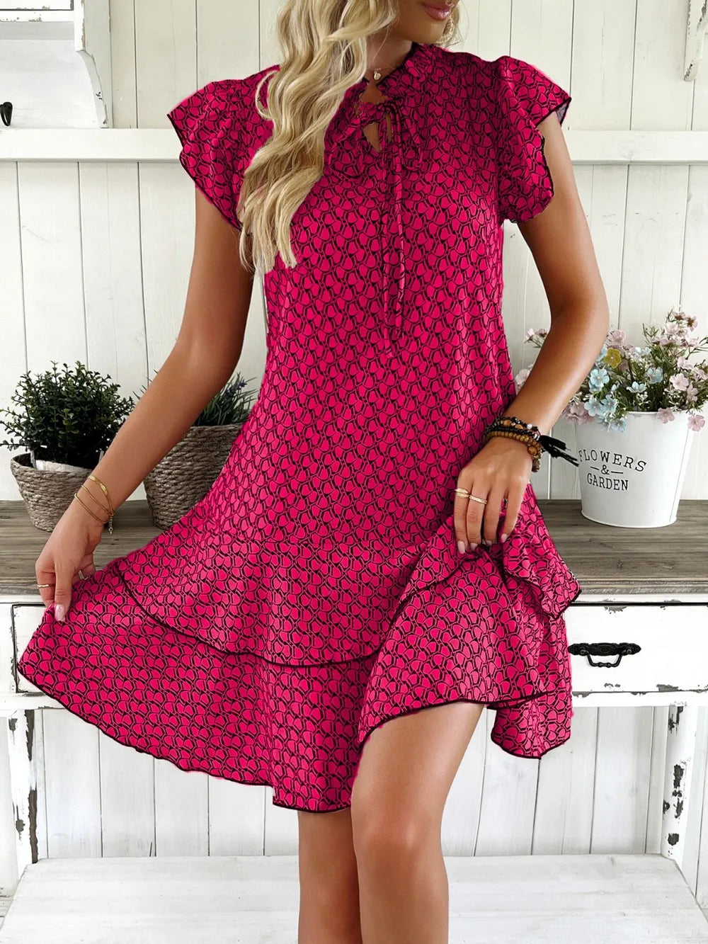 Woman wearing a pink patterned dress in a home setting