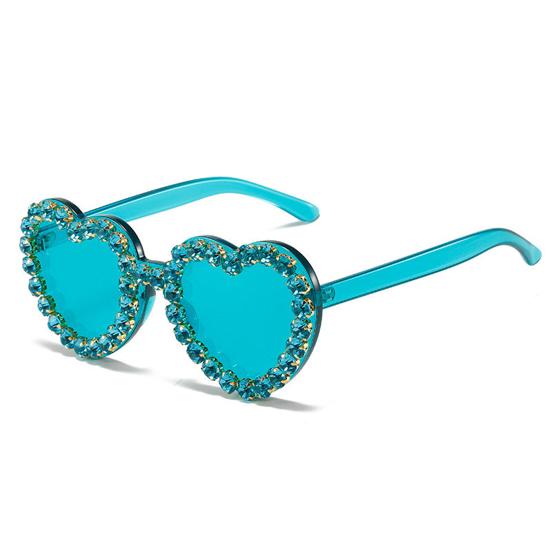 Turquoise heart-shaped sunglasses with gemstones on a white background