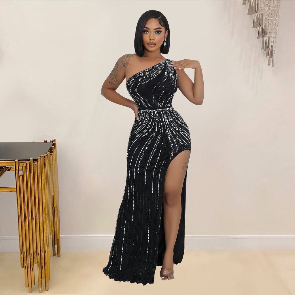 Woman wearing a black one-shoulder dress with silver embellishments in an indoor setting.