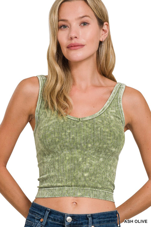 Woman wearing a green ribbed tank top on a white background