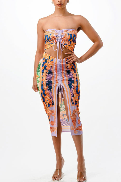 Woman wearing a colorful strapless dress with a slit on a white background