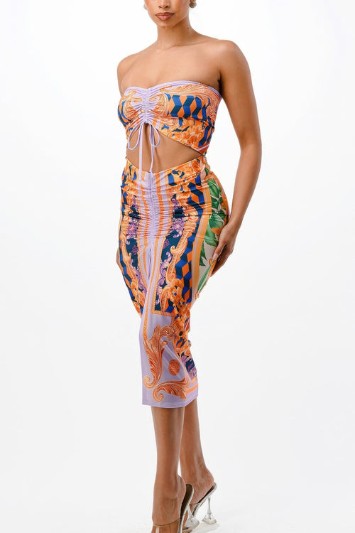 Woman wearing a colorful strapless dress with cut-out design on a white background
