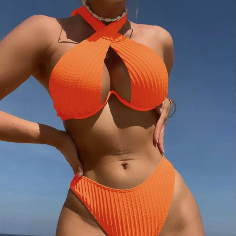 Person wearing an orange bikini against a clear blue sky