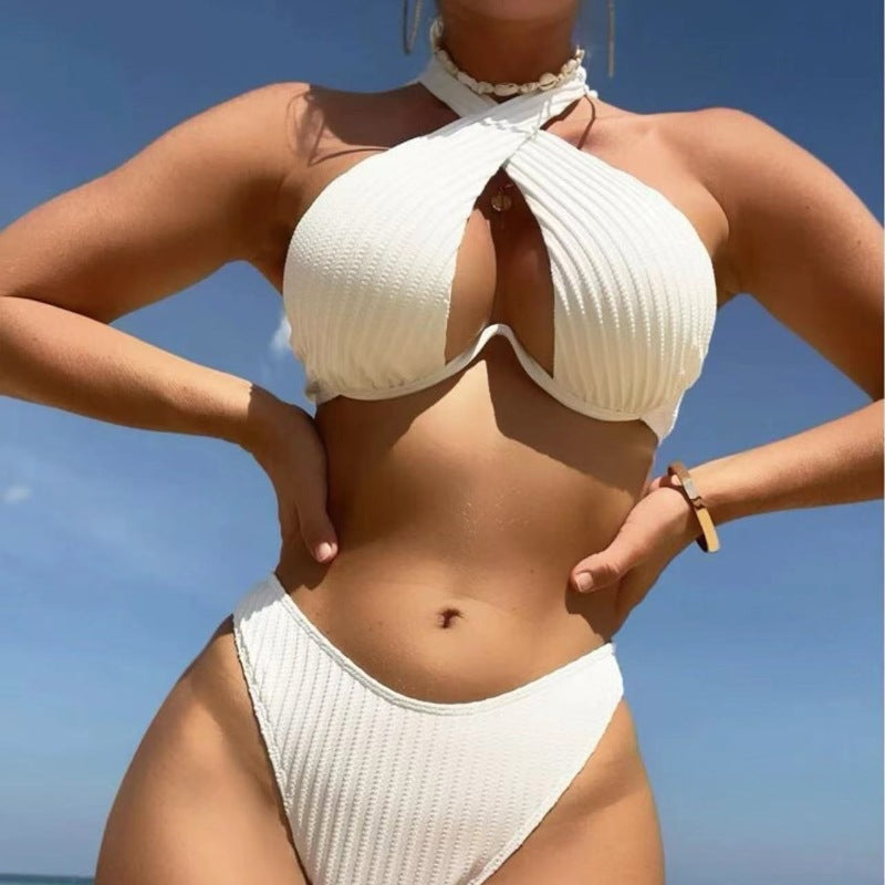 Person wearing a white bikini against a clear blue sky