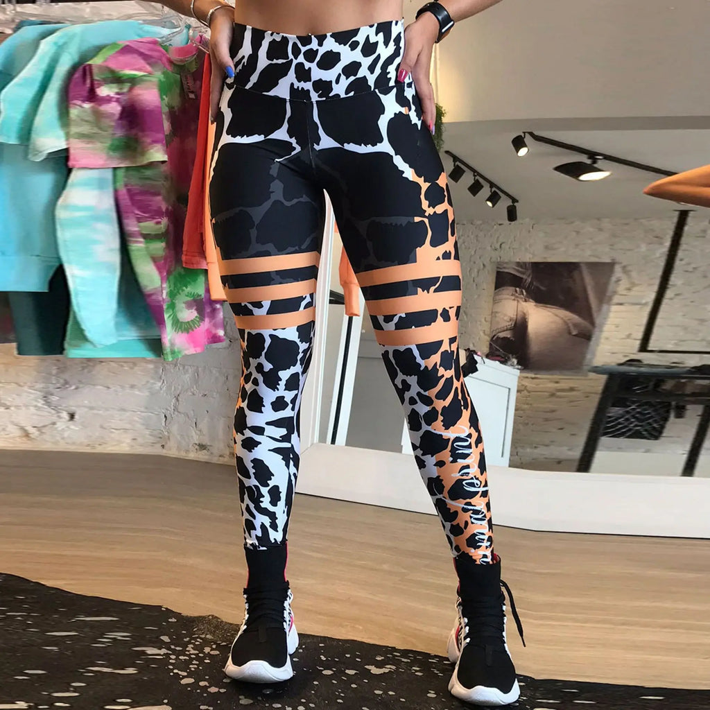 Person wearing colorful patterned leggings in a room with clothes in the background