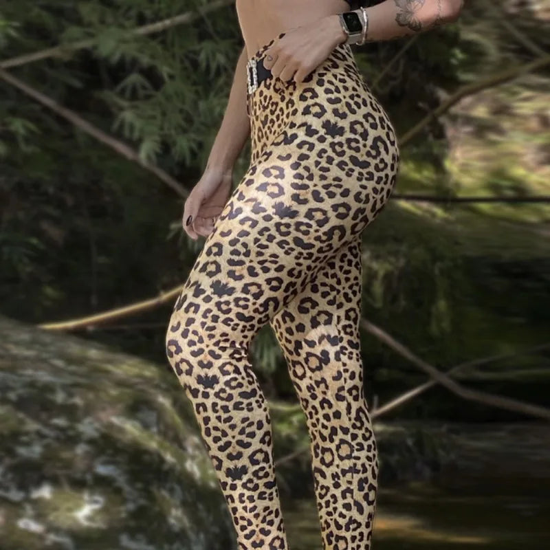 Person wearing leopard print pants standing in a natural setting with greenery.