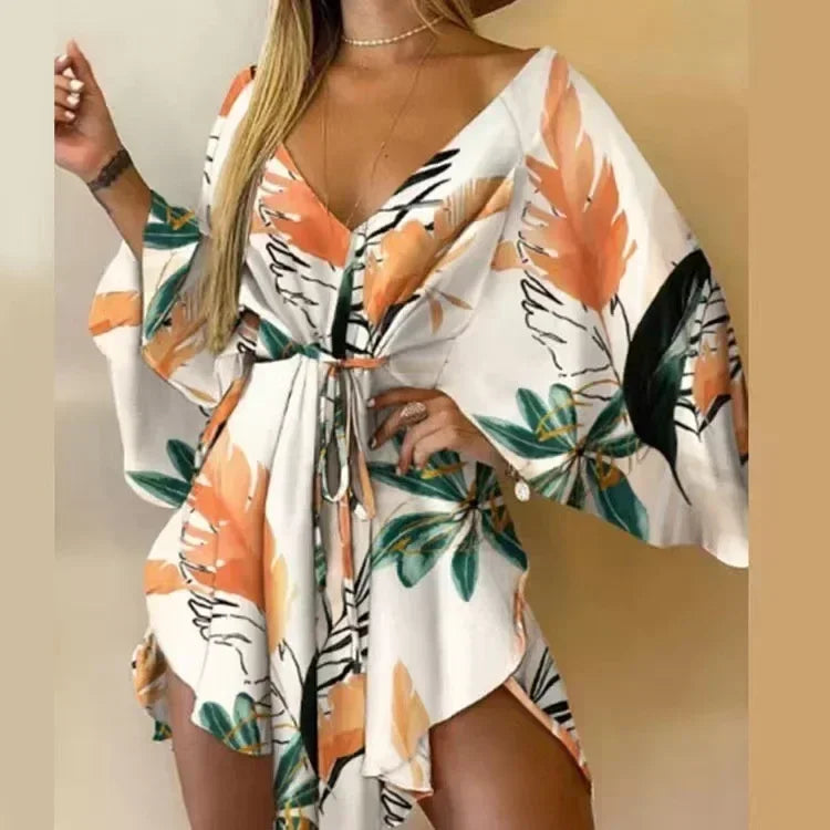 Woman wearing a floral kimono-style dress with orange and green leaves on a plain background