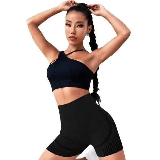 Woman wearing a black sports bra and shorts on a white background