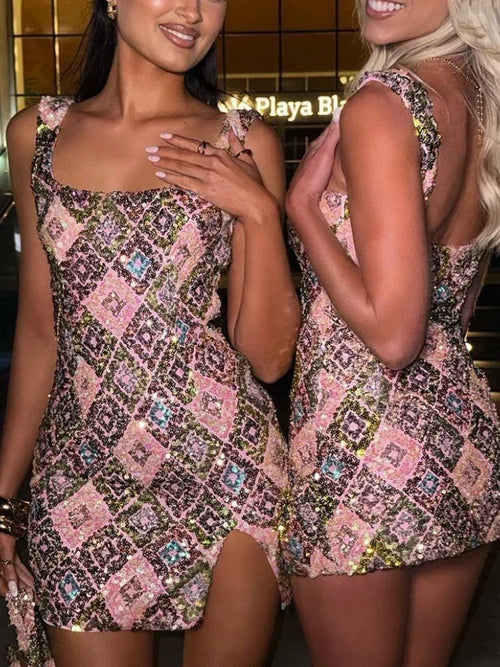Two women wearing patterned dresses standing close together.