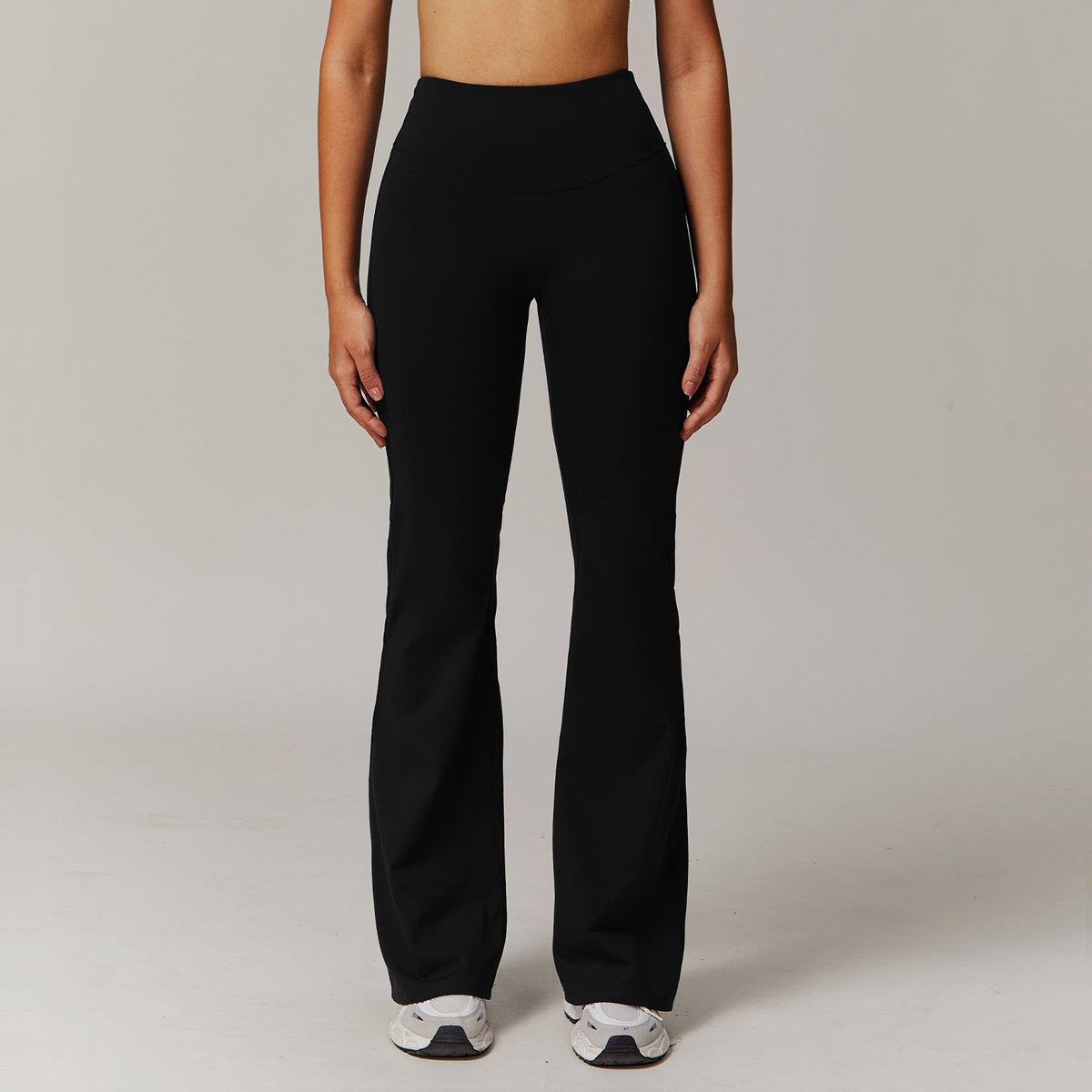 Person wearing black pants on a plain background