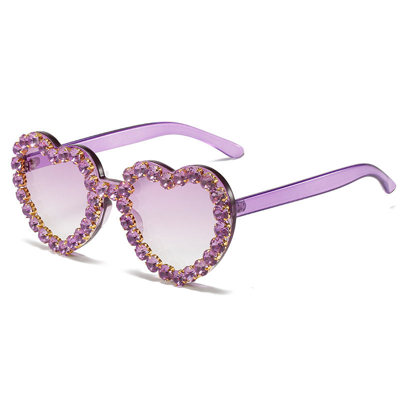 Heart-shaped sunglasses with purple frame and lenses on a white background