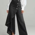 Person wearing a black denim skirt with a white shirt on a gray background