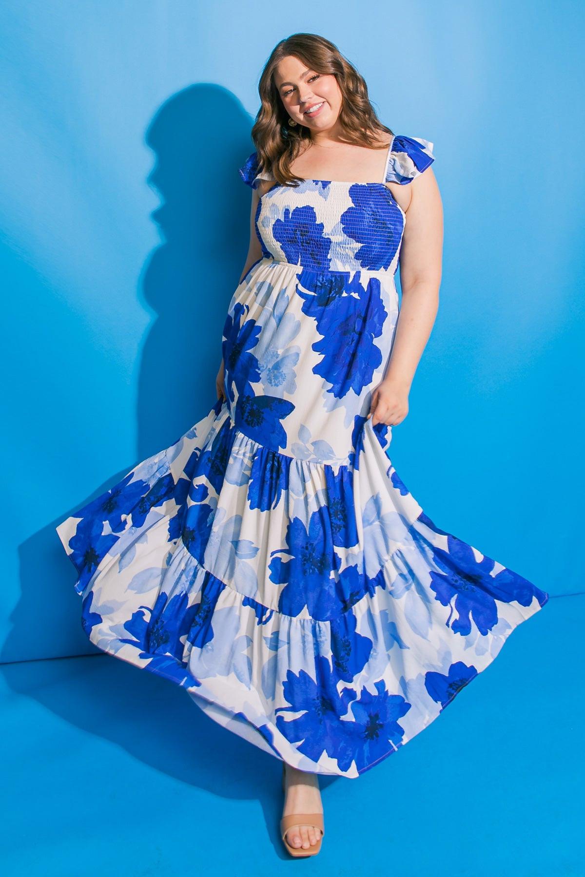 Woman wearing a blue floral dress against a blue background