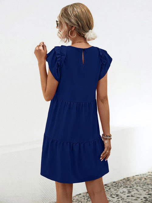 Woman wearing a blue dress with ruffled sleeves against a white background  & back of dres