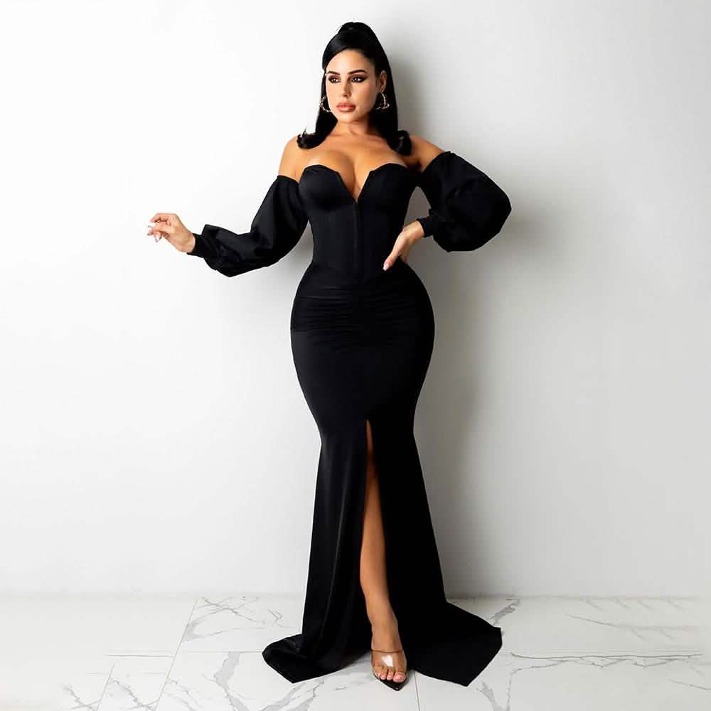 Woman wearing a black off-shoulder gown with a high slit on a white background