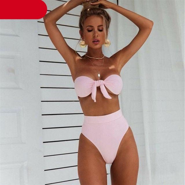 Woman wearing a pink bikini against a light background