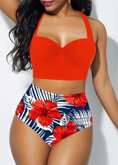 Woman wearing a red bikini top and floral high-waisted bottom against a white background